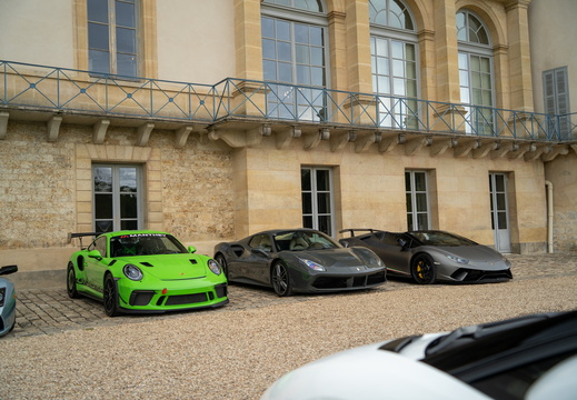 Trois supercars alignées dans la cour d'un château